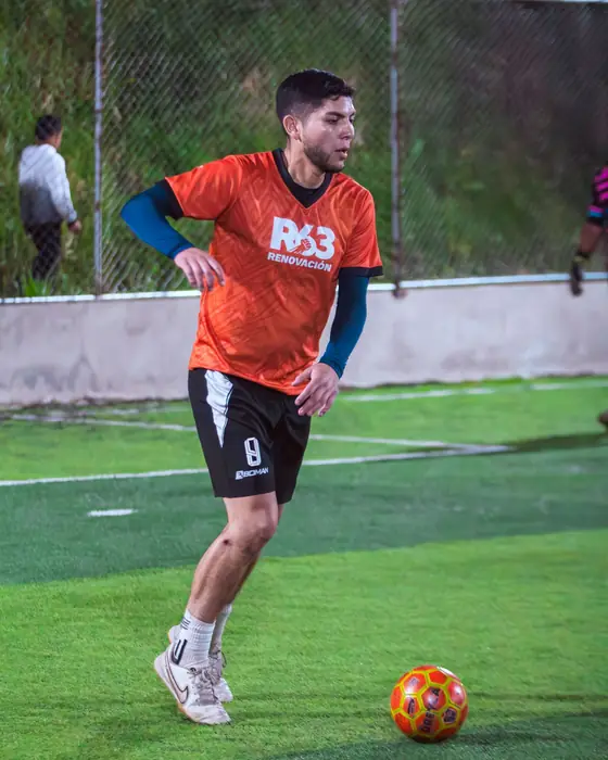 Jugador de naranja conduciendo el balón