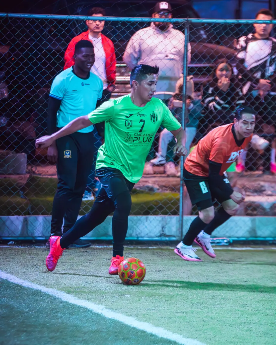 Jugador de verde conduciendo el balón junto a la línea